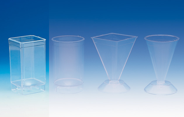 Transparente quadratische Quader-Gießform für Kerzen (48x48x80mm) mit Docht, Fixierstab und Knetmasse auf weißem Grund.