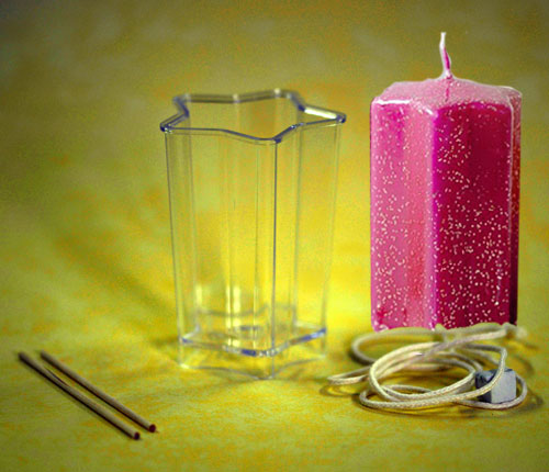 Kleine transparente Stern-Gießform für Kerzen (60x80 mm) inklusive Docht, Fixierstab und Knetmasse auf weißem Hintergrund.