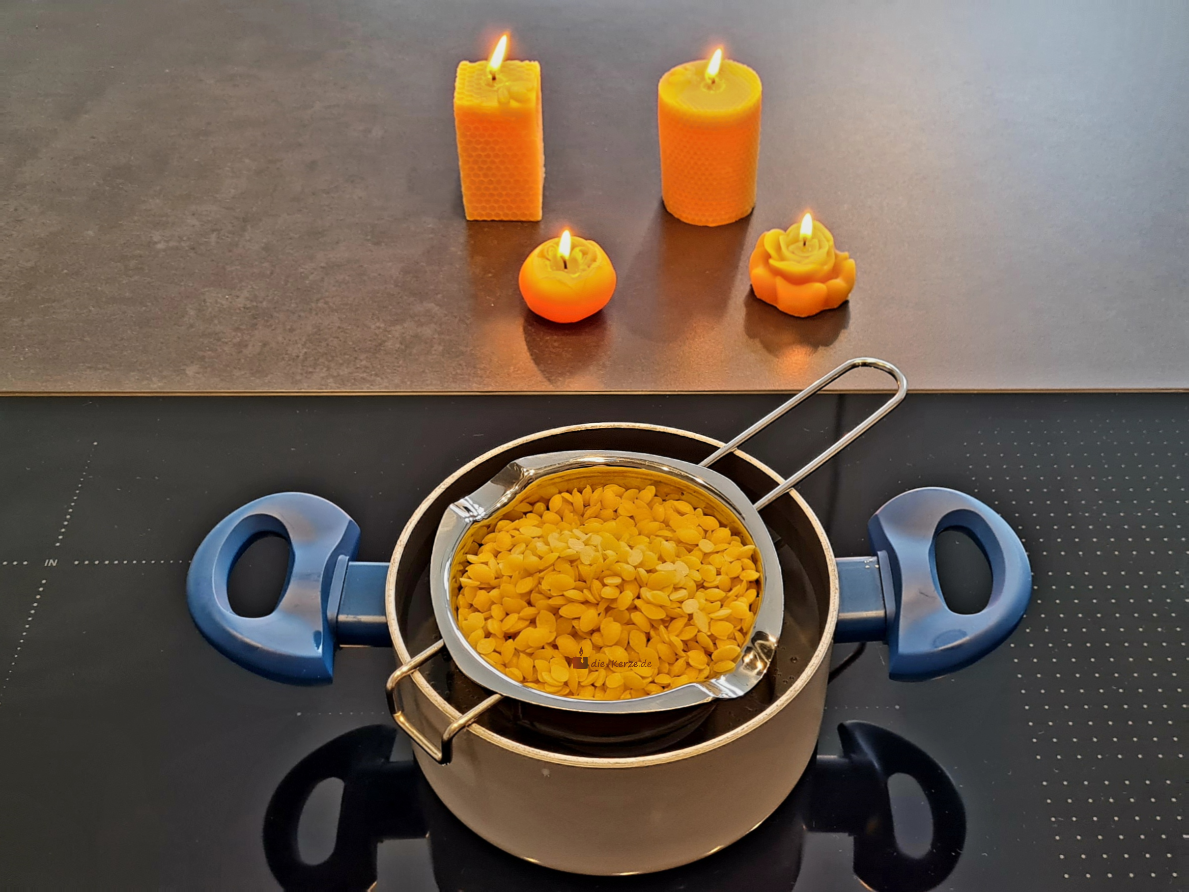 Schmelztopf aus Edelstahl mit 400ml Fassungsvermögen in einem Wasserbad, gefüllt mit schmelzenden gelben Bienenwachs-Pastillen zum Kerzen selber machen.